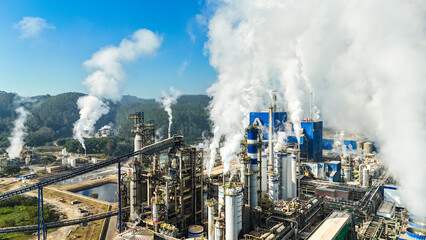 Grande indústria de papel e celulose operando a todo vapor, com galpões, caldeiras e áreas de produção ativa. Destaque para o movimento industrial e estrutura robusta