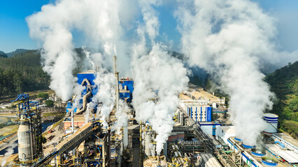 Vista aérea de chaminés liberando poluentes e emissões atmosféricas em uma indústria de papel e celulose, com destaque para o impacto ambiental.