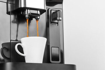 Fresh espresso streams into a white cup from a modern coffee machine, creating the perfect start to...