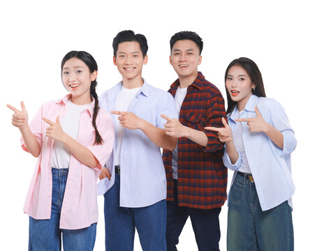 Group of four young adults pointing to the side showcasing something with positive expressions