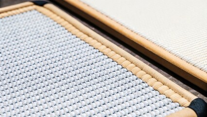 Two rectangular wicker placemats, one light blue and one white, lying on a dark surface, showcasing their intricate woven texture