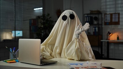 Humorous Office Scene with Ghost Costume at Desk