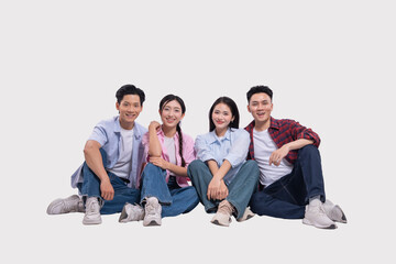 Four young adults sit together casually dressed and smiling on a white background radiating youth