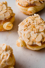 Close-up of almond cream-filled pastries topped with sliced almonds and glaze, arranged on a light background. Delicious gourmet bakery treats perfect for dessert, pastry, and food photography concept