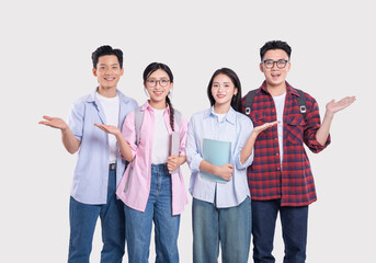 Group of Smiling Students: Two women and two men in casual outfits point outwards with happy...