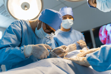 A group of surgeons are performing a surgery on a patient