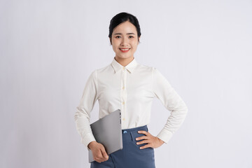 Professional woman ready to work: Smiling businesswoman holding a laptop in a modern office setting
