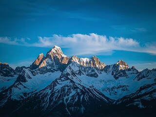 Majestic mountain peaks soar against a stunning blue sky, showcasing snowy summits in a breathtaking alpine landscape.