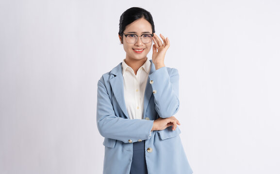 Professional woman wearing glasses and a light blue blazer smiling in front of a white background