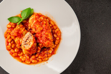 Stuffed cabbage tomato sauce with beans meat, cabbage, fresh delicious gourmet food background on the table rustic food top view copy space