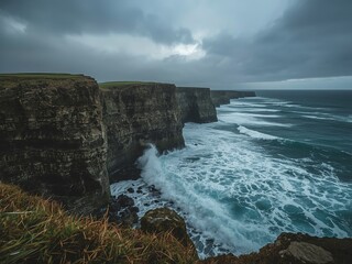 Dramatic Cliffs of Moher in Ireland meet the powerful Atlantic Ocean under a cloudy sky, showcasing a stunning landscape