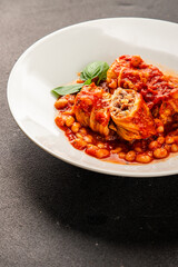 Stuffed cabbage tomato sauce with beans meat, cabbage, fresh delicious gourmet food background on the table rustic food top view copy space