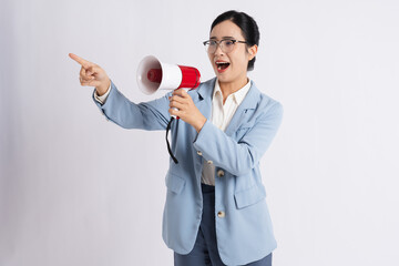 Enthusiastic professional woman with glasses using a megaphone while pointing on a white background