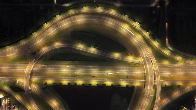 Aerial view of illuminated cloverleaf interchange over canals at night