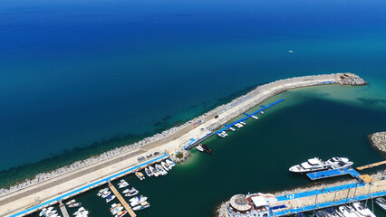 Calm blue sea surrounding Tropea harbor with many recreational boats moored to the docks