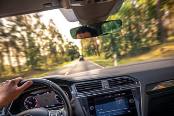 Fast car motion. Driver behind wheel. Interior road view.