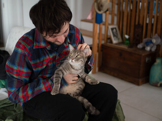 Moment de complicité entre un homme et son chat gris se regardant avec tendresse