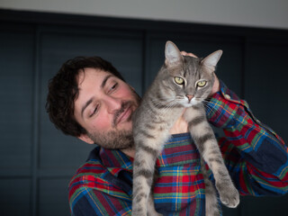 Homme tenant fièrement son chat gris