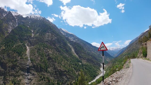 4K shot of river Chenab flowing between the two Himalayan mountain peaks with clouds above it as seen on the way towards Udaipur in Pattan valley, Lahaul, Himachal Pradesh, India. Scenic background.