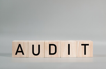 Wooden blocks spelling out the word AUDIT. This image represents the successful completion of a thorough audit, providing a strong foundation for business growth and investor confidence