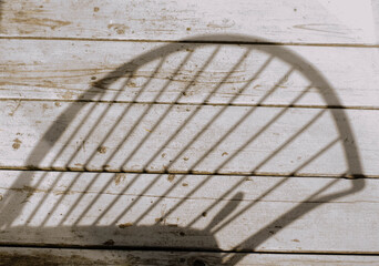  Shadow of a Chair on Rustic Wooden Deck