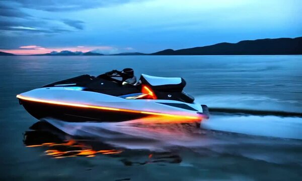 A white speedboat speeding across a body of water at dusk, with the sky transitioning from blue to shades of orange and pink. The boat casts a reflection on the water, and the setting sun