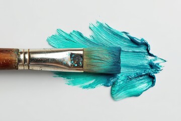 White surface with paint brush and turquoise teal paint in artistic layout
