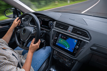 Fototapeta premium Modern female driver. Car interior with navigation. Highway driving motion