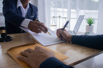 Lawyer at desk in office with legal documents and hammer, giving advice on justice, contracts,...