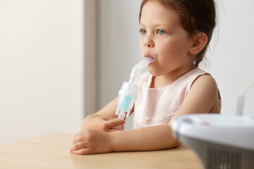 cute little toddler girl making inhalation with nebulizer, copy space