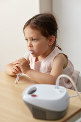 cute little toddler girl making inhalation with nebulizer
