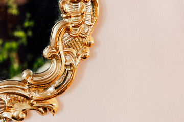 Elegant golden mirror frame showing intricate design in a bright setting during the day
