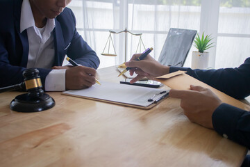 Lawyer at desk in office with legal documents and hammer, giving advice on justice, contracts,...