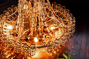 Elegant chandelier with crystal details illuminating a warm interior space during evening hours