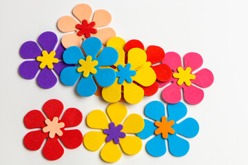Artistic arrangement of colorful felt flowers on a white surface showcasing creativity