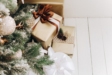 Christmas gifts beautifully wrapped and placed under the tree in a cozy indoor setting