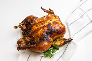 Juicy roasted chicken garnished with fresh herbs on a white platter