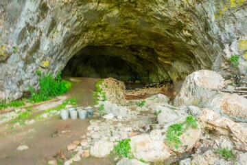 view of a cave in the mountains of the Western Caucasus, where archaeological excavations are being carried out at an ancient human site on a sunny summer day