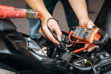 Mechanic using a multimeter check motorcycle electrical system  find wiring problems . work in...