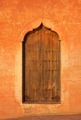 Morocco Marrakesh typical old arabesque door surrounded by rustic terracotta colored wall - Menara Pavilion