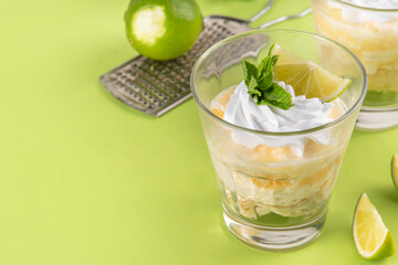 Summer mojito tiramisu dessert, Lime and mint sweet sour taste version of summer tiramisu layered cake with fresh citrus curd, mascarpone and savoyardi. Portion mojito tiramisu parfait dessert