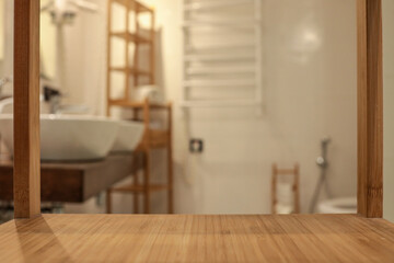 Empty bamboo shelf surface in focus with blurred modern bathroom background. Cozy spa interior with...