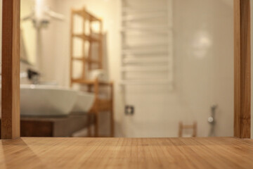 Empty bamboo shelf surface in focus with blurred modern bathroom background. Cozy spa interior with...