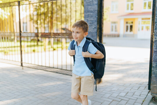 Boy Walking Home from School in Uniform with Backpack After Class