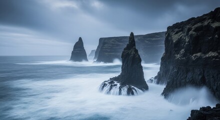 Dramatic seascape of basalt columns and powerful waves crashing against volcanic cliffs.