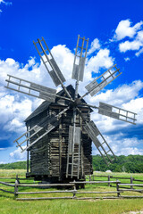 Rural old wooden mill against the sky