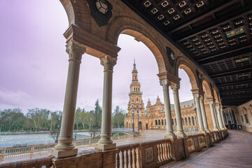 Sevilla Plaza de Espana in Spain captures a rainy twilight with an ornate arcade and colorful...