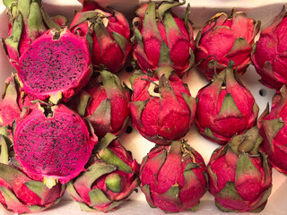 Vibrant dragon fruit display revealing bright pink flesh during market visit