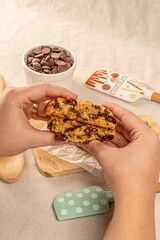 hands holding a chocolate chip cookies