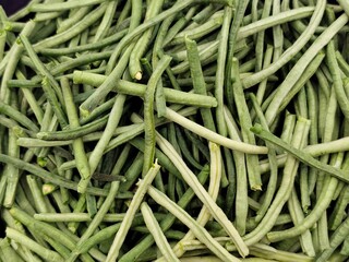 Closeup view of freshly trimmed and cleaned string beans (ambelofasoula in Greek) in a bowl, isolated on white background.